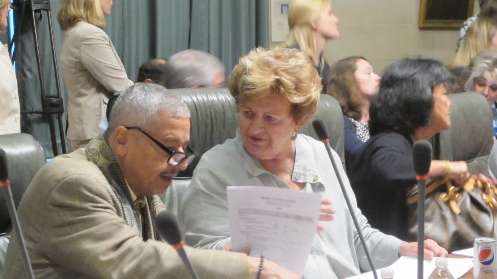 Regents Luis Reyes and Beverly Ouderkirk go over some paperwork at July's Board of Regents meeting.