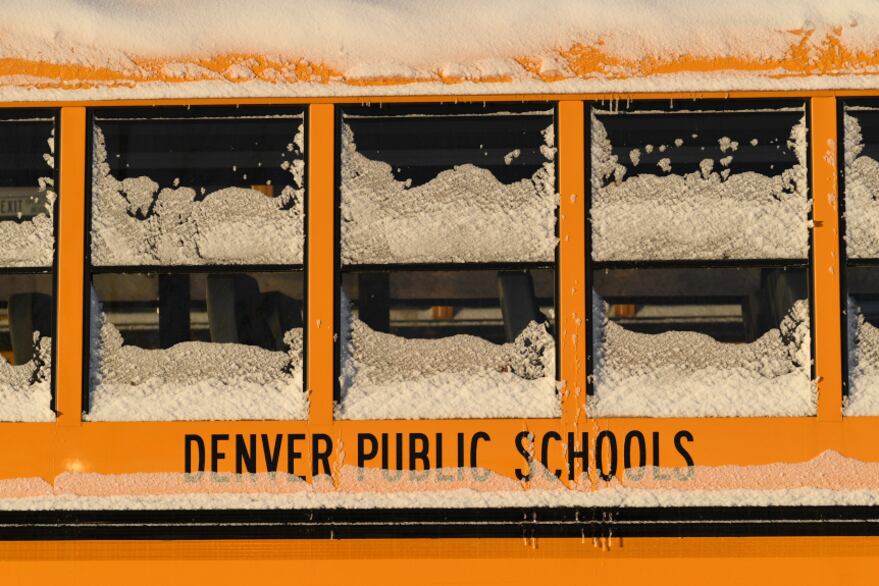 Snow and ice cake the windows of a yellow school bus