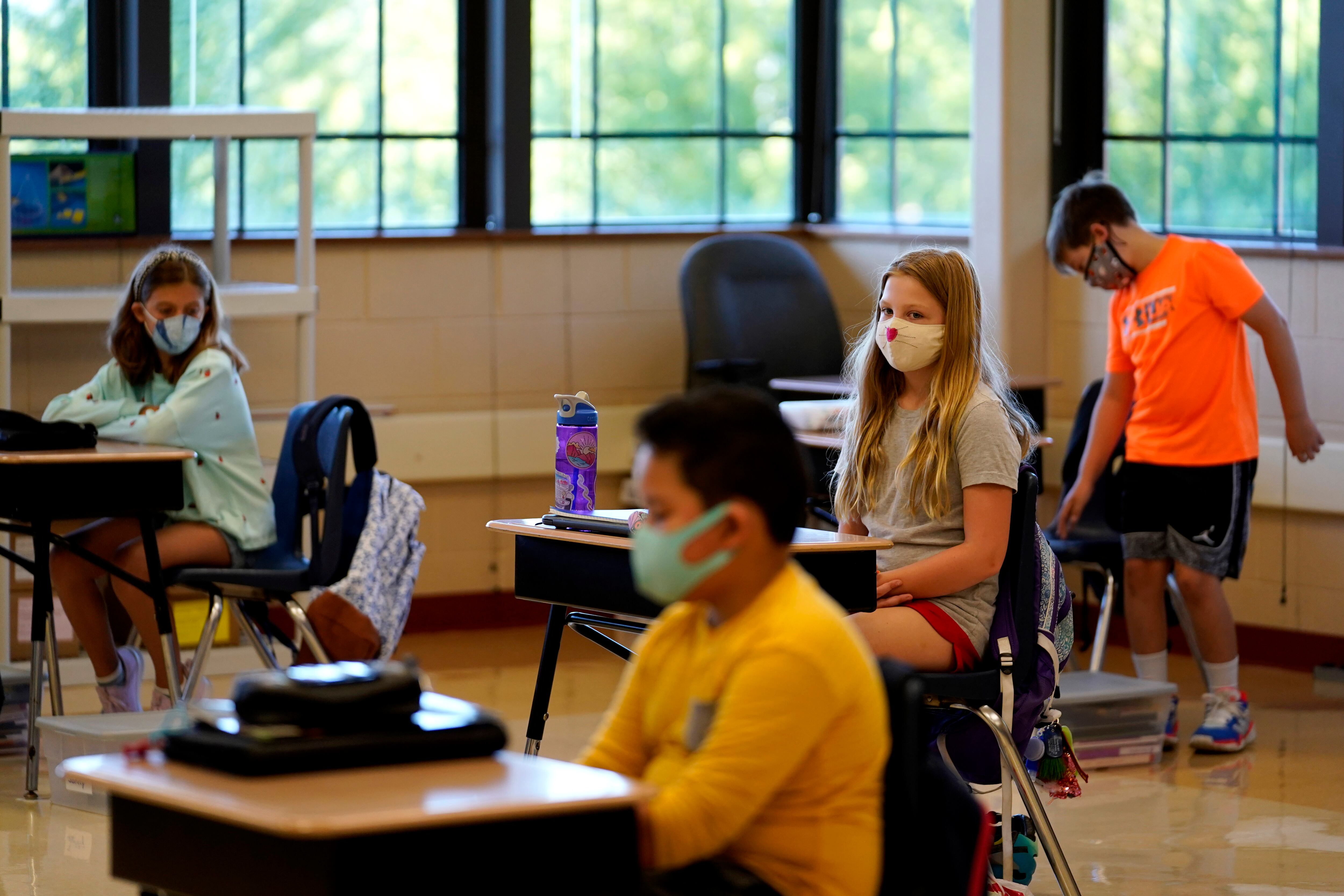 Fifth grade students wear masks as they wait for their teacher in the classroom at Oak Terrace Elementary School in Highwood, Ill.