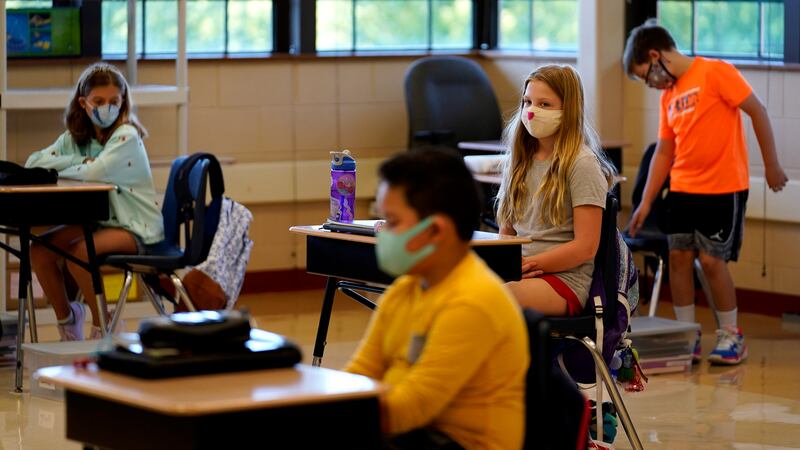 Fifth grade students wear masks as they wait for their teacher in the classroom at Oak Terrace Elementary School in Highwood, Ill.
