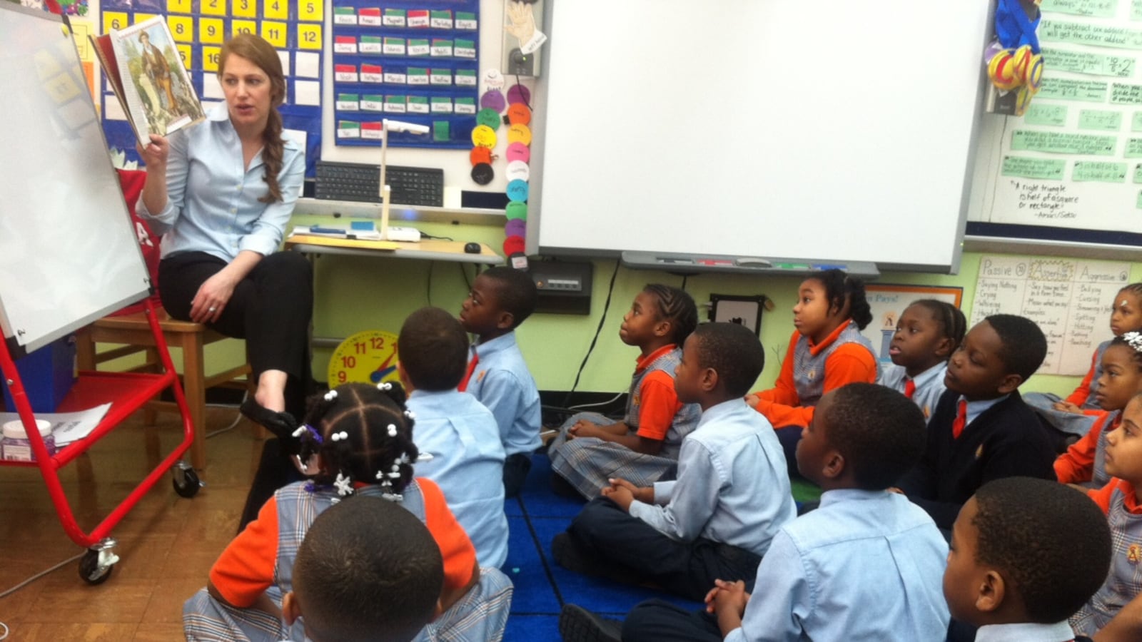 A third-grade teacher at Success Academy, reads to her students.