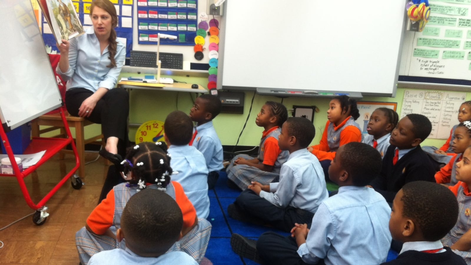 A third-grade teacher at Success Academy, reads to her students.