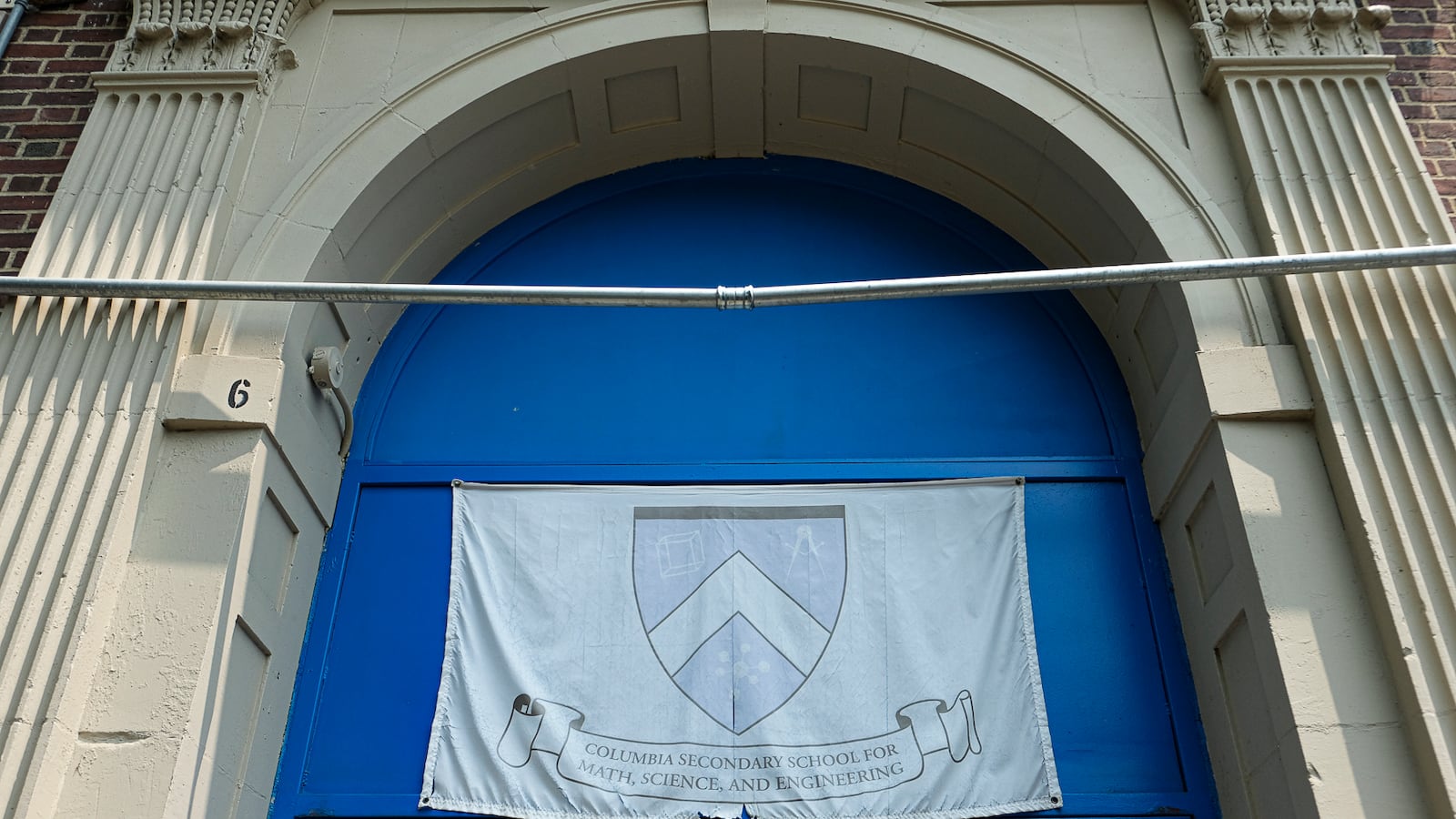 A banner hangs above two blue doors.