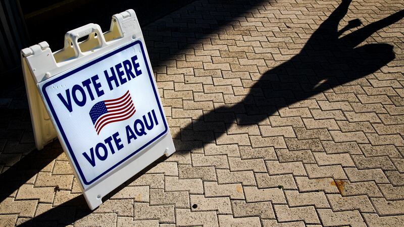 A sign reads, “Vote here, vote aqui.”