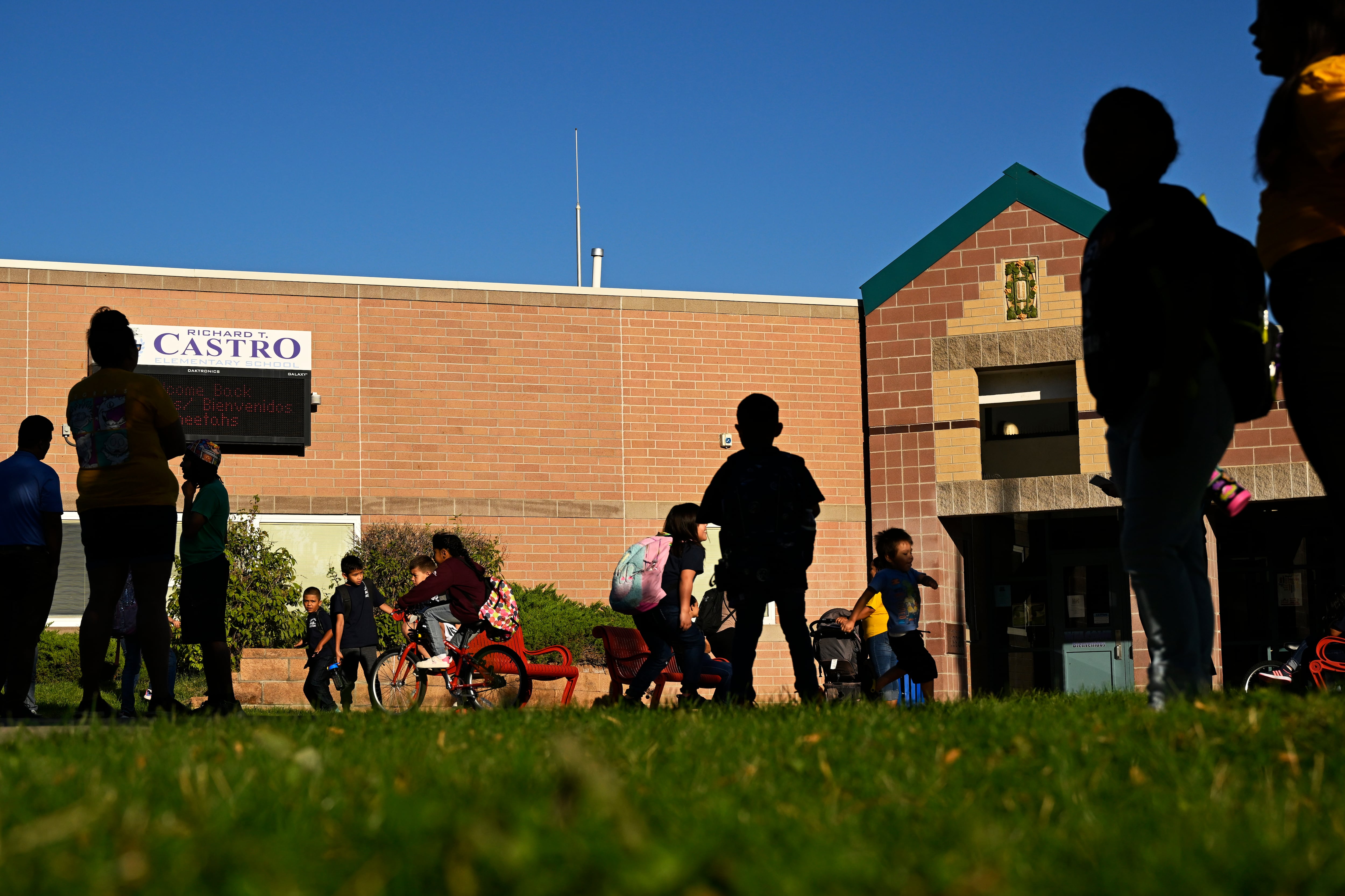 Students and parents are silhouetted as they arrive to Castro Elementary in the morning.
