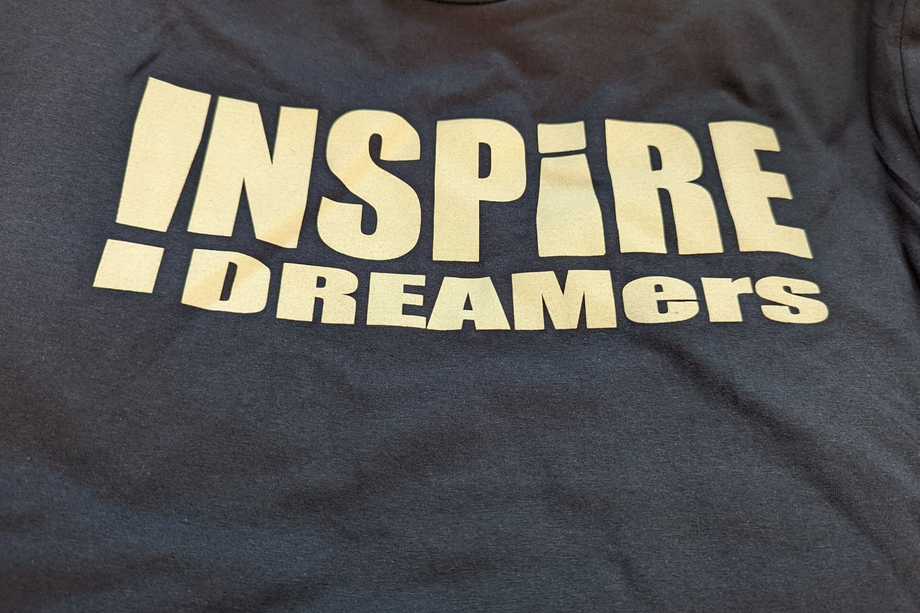 A blue shirt with the words INSPiRE Dreamers on the front.