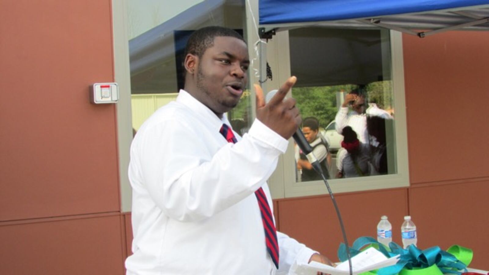 Student Quentin Brown welcomes dignitaries to the new Carpe Diem Shadeland charter school.
