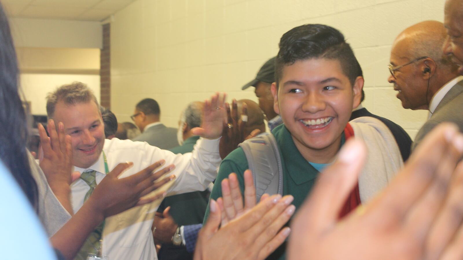 Most of the teenagers broke out into smiles, slapping at the outstretched hands as they waded through the hallway.