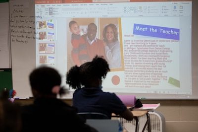 Students listen intently as their teacher Will Cannon presents a slideshow about his background and personal life during his class.