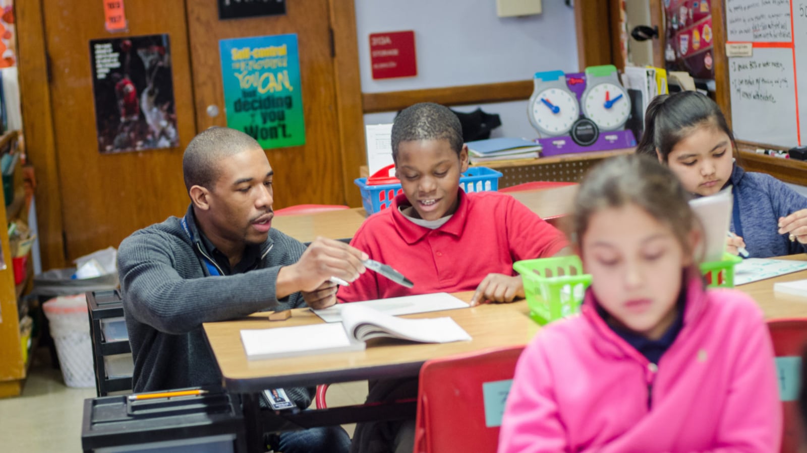 Treadwell Elementary math teacher Neven Holland, a graduate of the Memphis Teacher Residency program, helps his fourth-grade student with a problem.