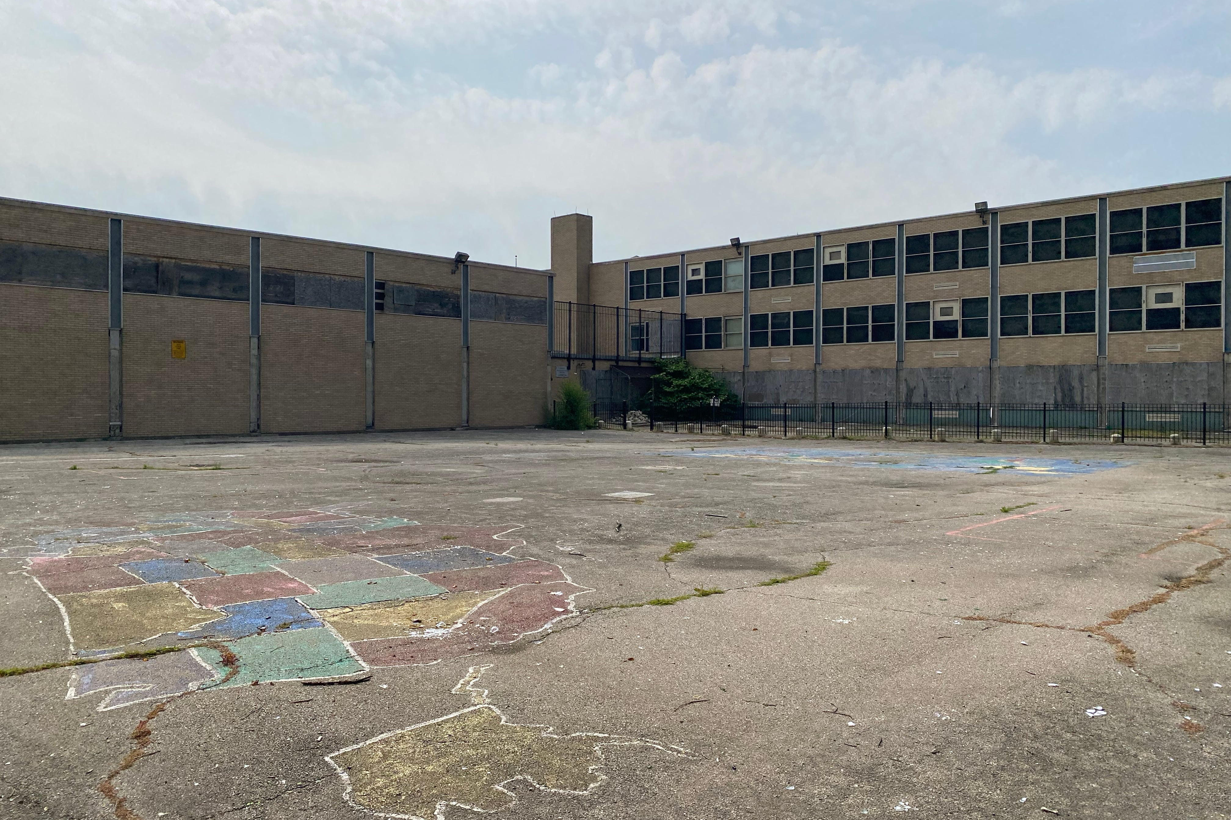 The empty cracked blacktop behind an elementary school in Chicago.