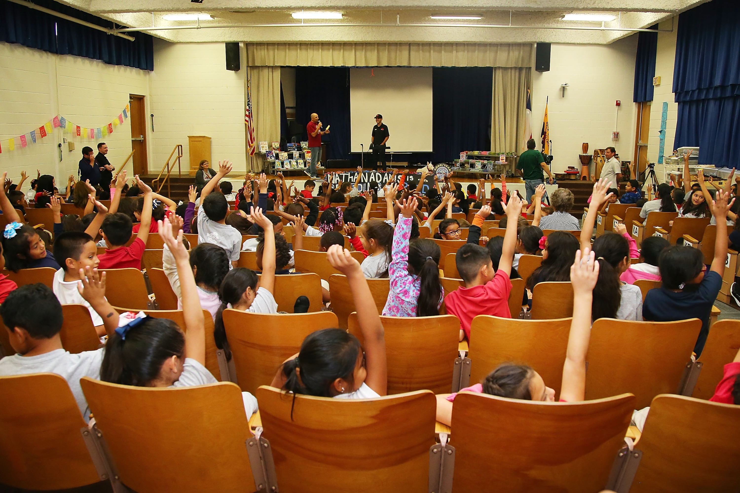 Dallas elementary school students raise their hands at an event in 2016.