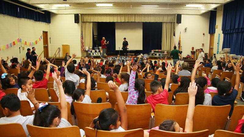 Dallas elementary school students raise their hands at an event in 2016.