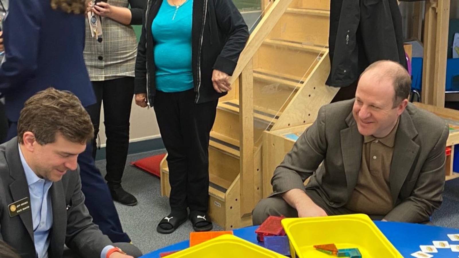 State Sen. Jeff Bridges and Gov. Jared Polis play with geometric tiles on a visit to Village for Early Childhood Education at North.