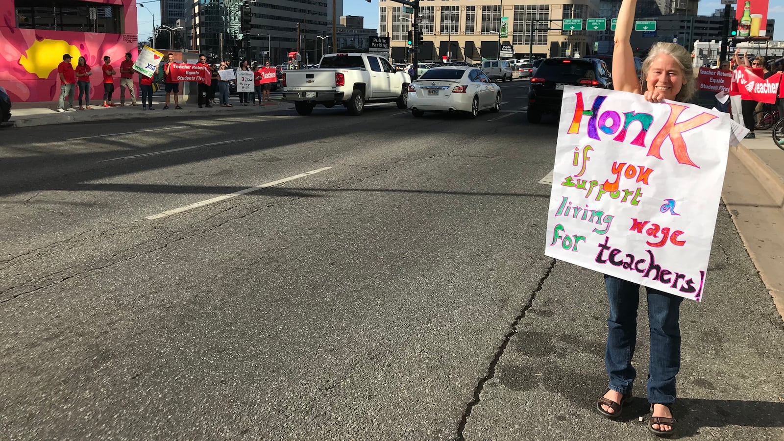 A Denver teacher rallies support for increased teacher pay in front of the school district headquarters in September 2018.