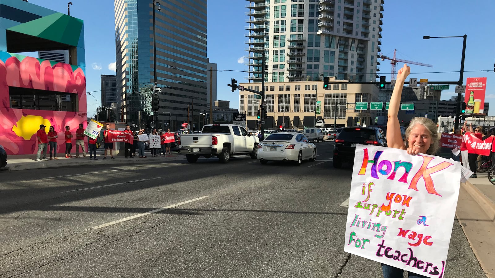 A Denver teacher rallies support for increased teacher pay in front of the school district headquarters in September 2018.