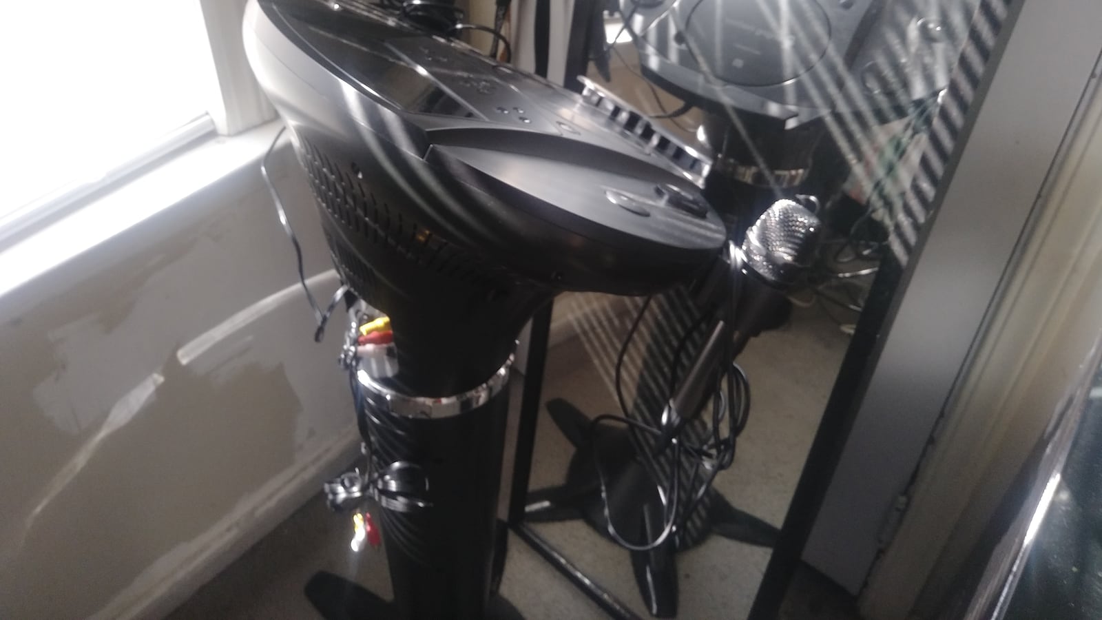 A karaoke machine beside a mirror.