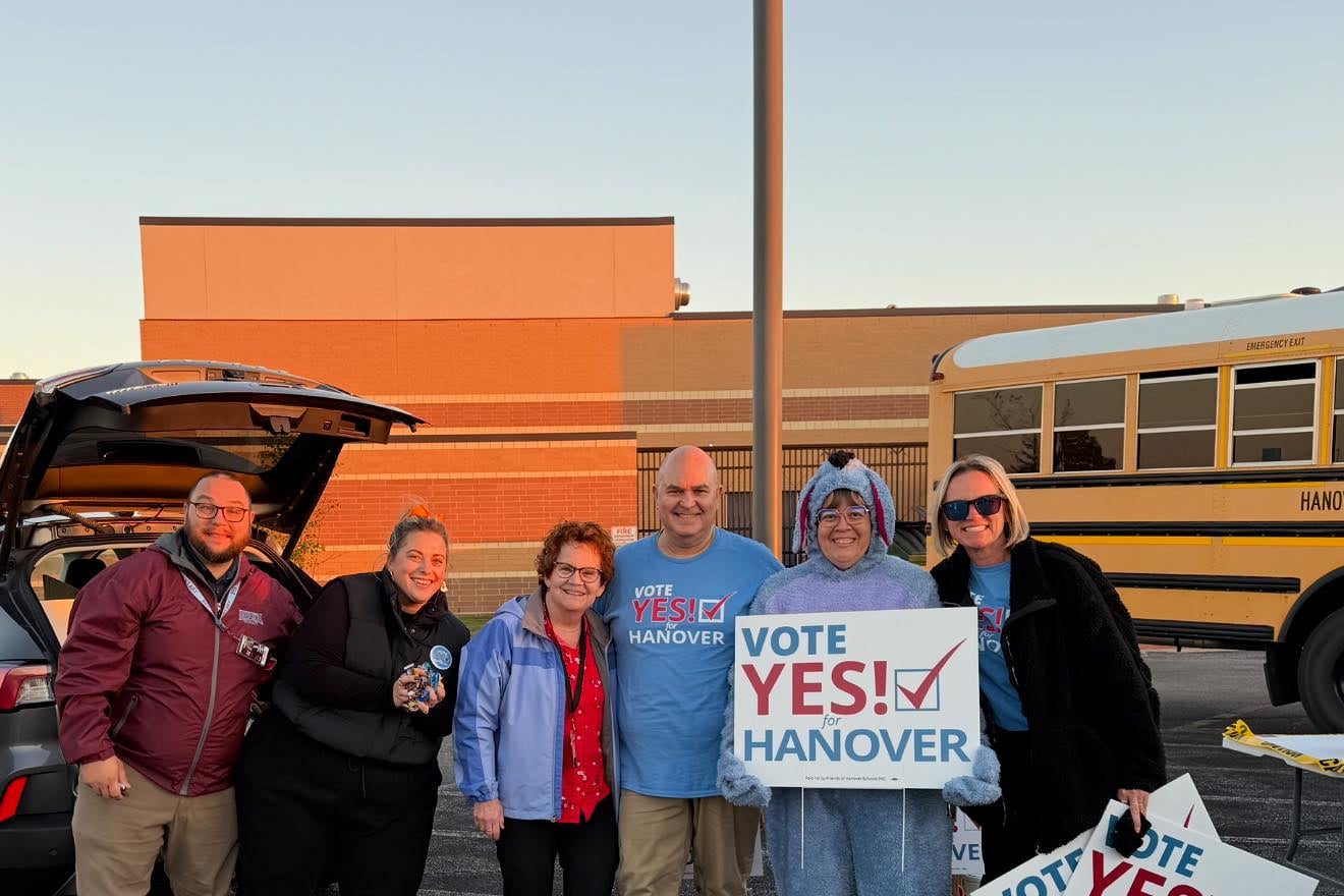 People hold signs in front of a bus.