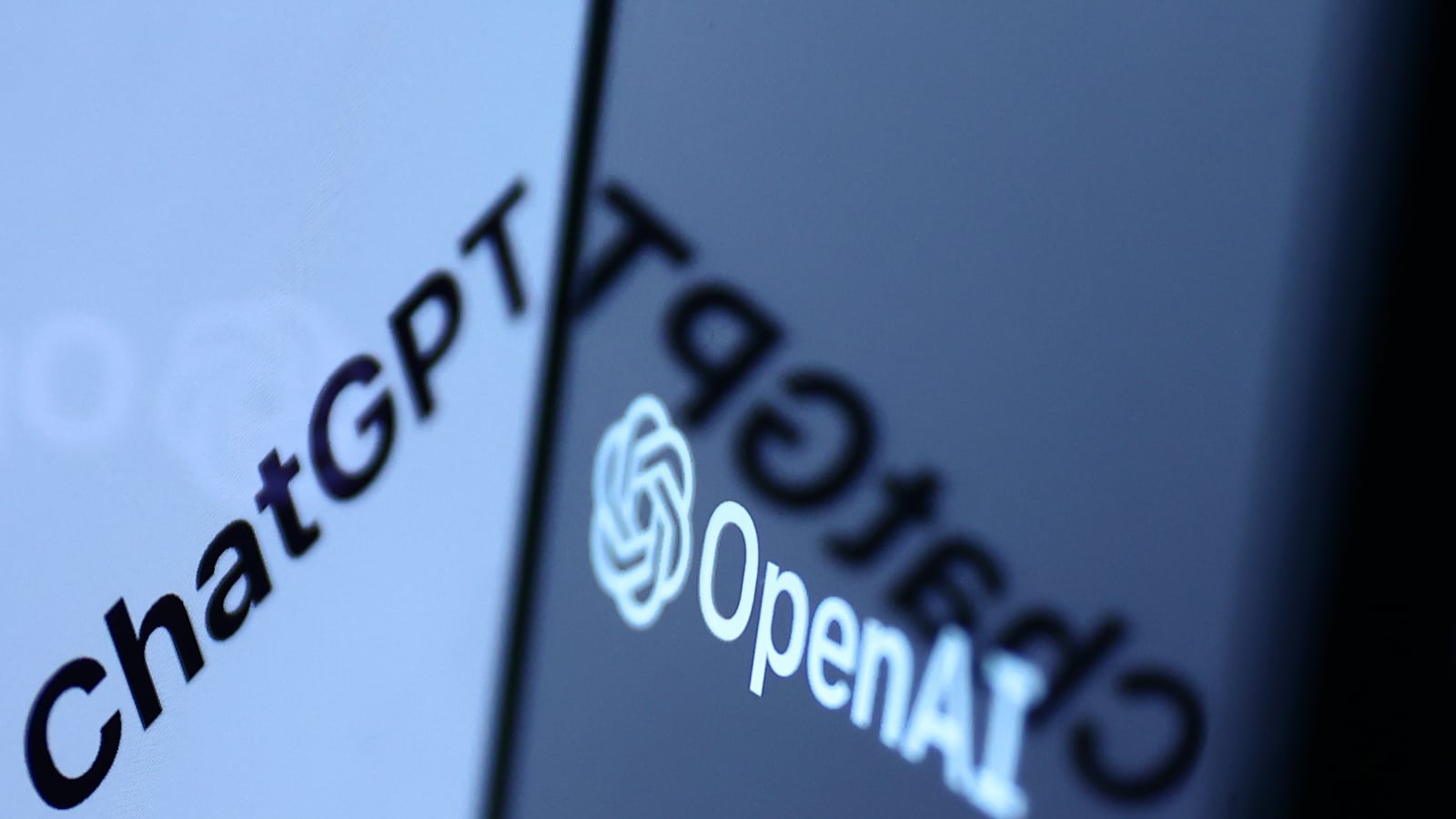 ChatGPT sign in the website displayed on a laptop screen and OpenAI logo displayed on a phone screen.