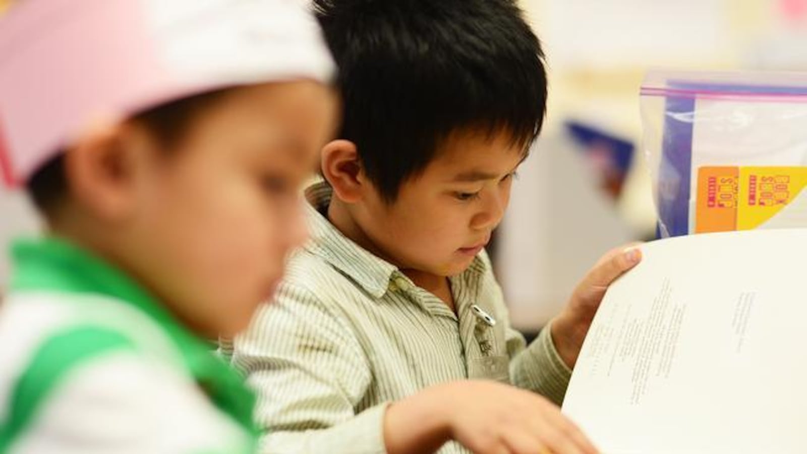 A kindergartner flips the page while reading in class at Crawford Elementary in Aurora.