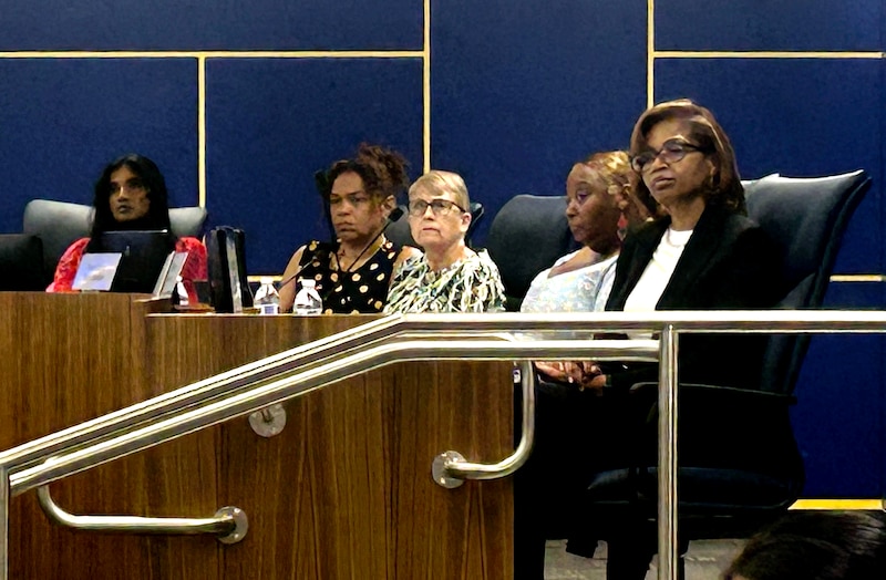 A group of women sit at the front of a meeting.