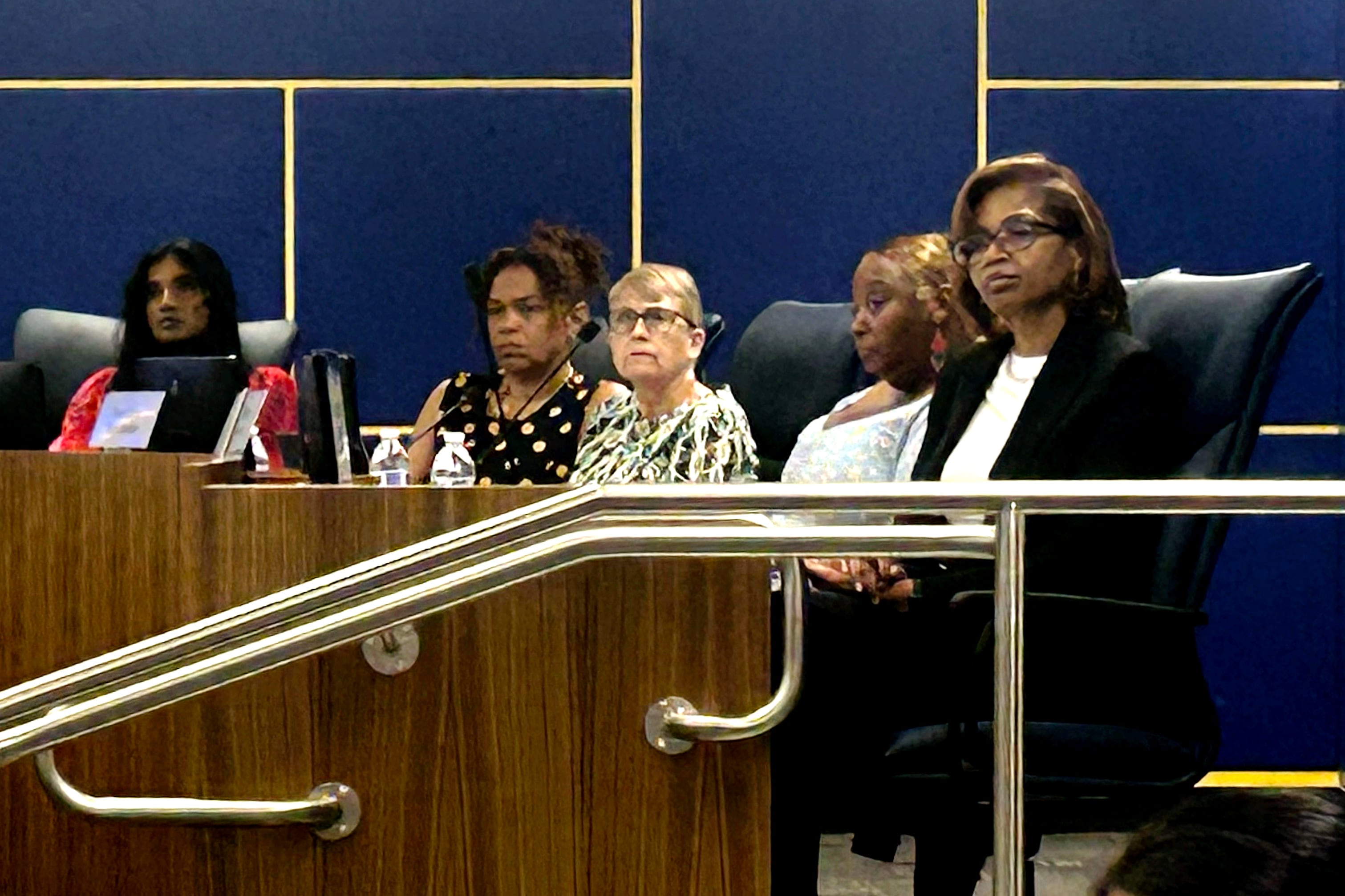 A group of women sit at the front of a meeting.