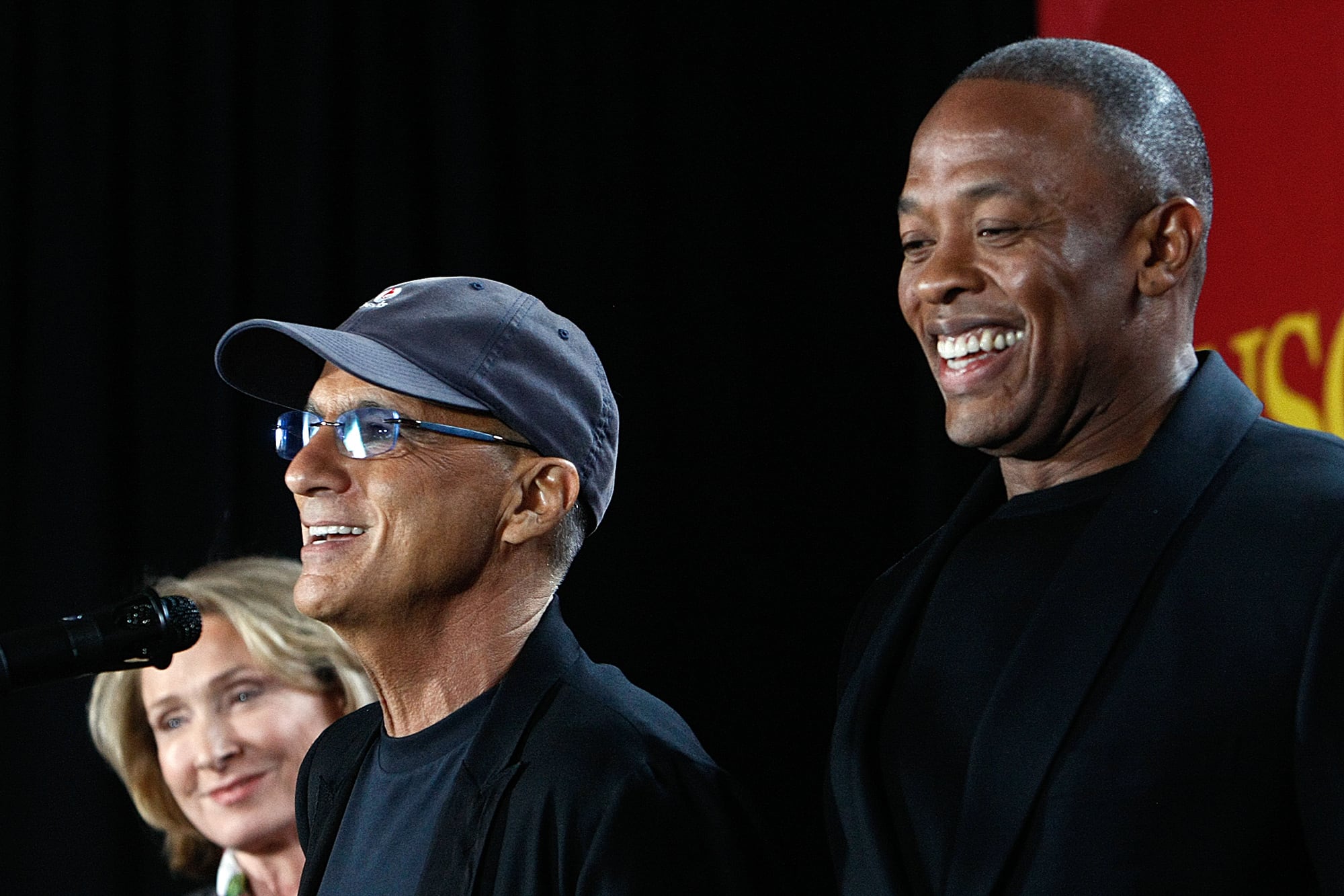 A photograph of Jimmy Iovine, left, and Rapper Dr. Dre, standing next to each other against a black backdrop.