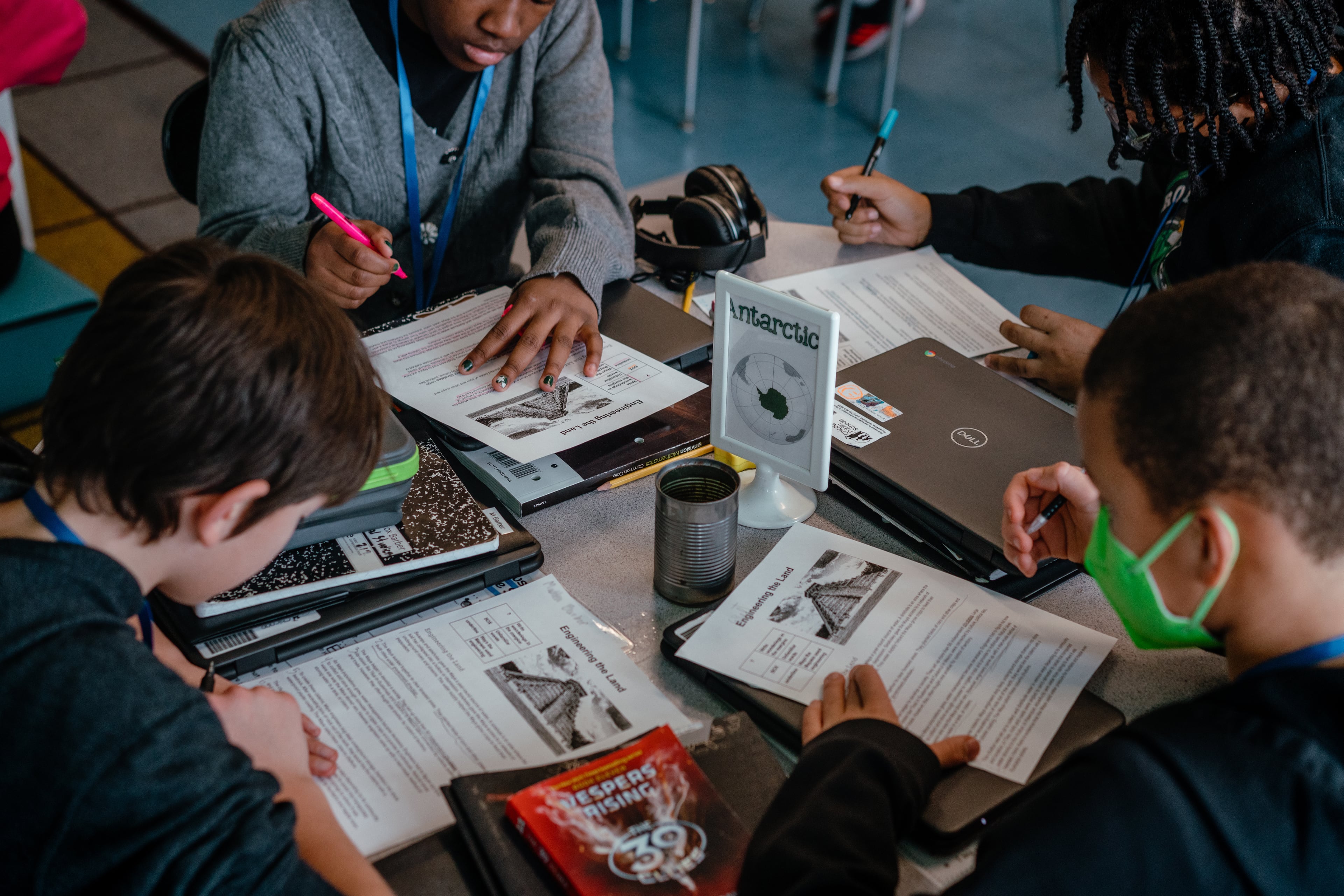 A group of four students work on worksheets together at their desks. The district has enrolled a smaller and smaller share of students from low-income families over the past decade.