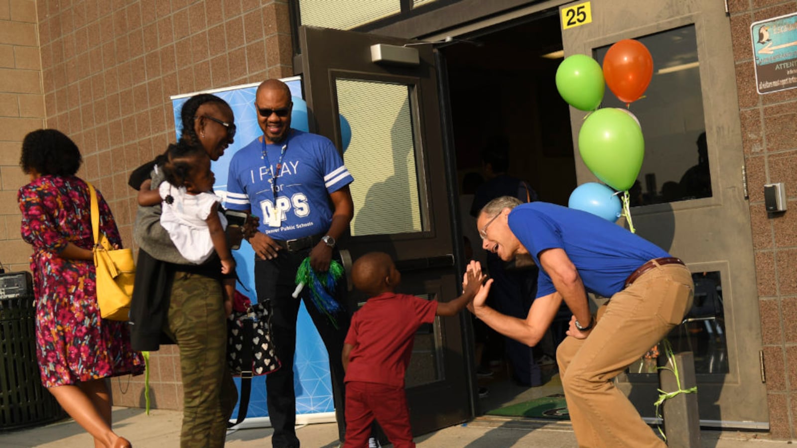 Denver Superintendent Tom Boasberg, right, high-fives students, parents, and staff on the first day of school at Escalante-Biggs Academy in August.