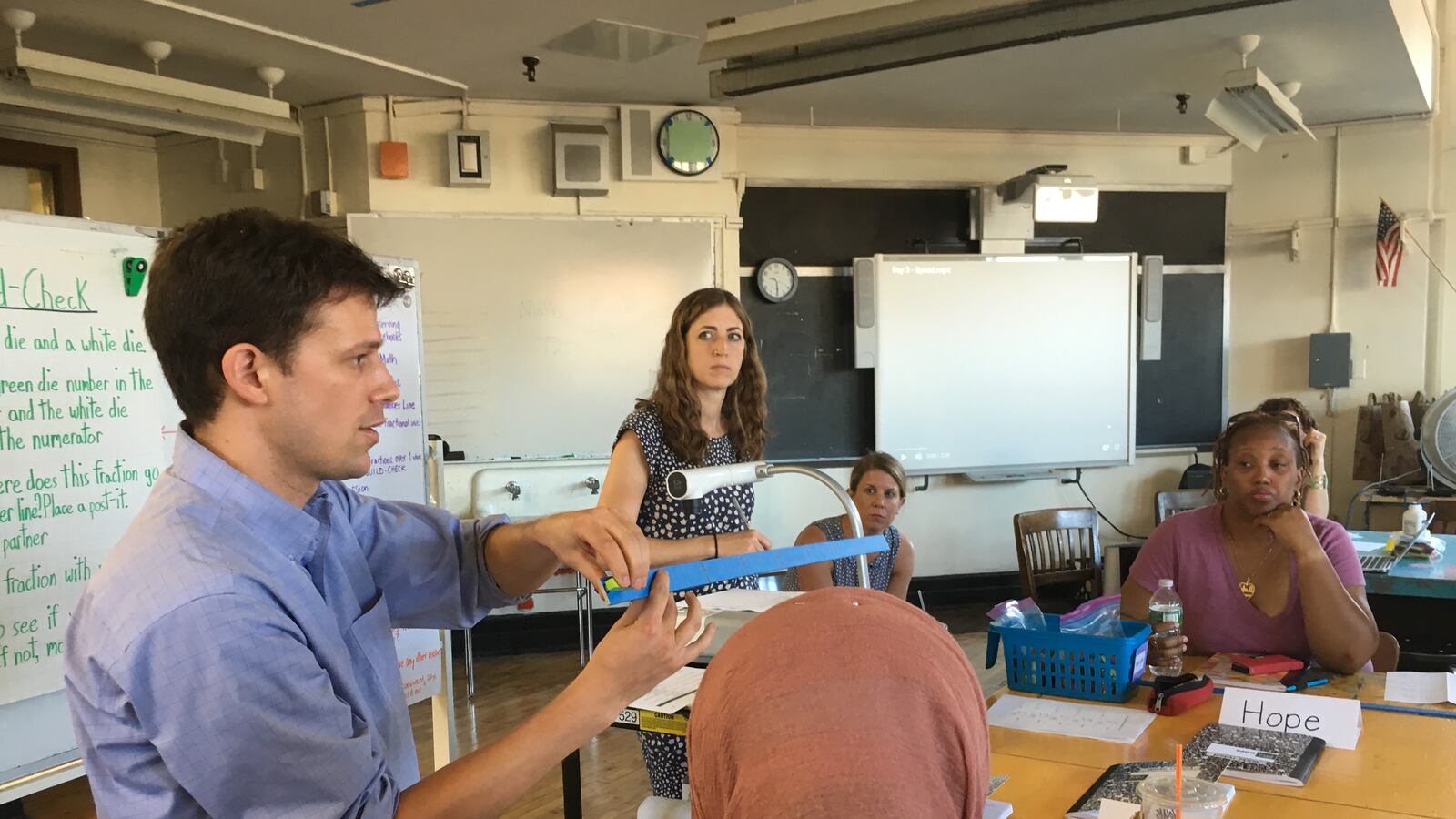Math Lab co-founder Peter Cipparone walks teachers through the morning's lesson before students arrive.