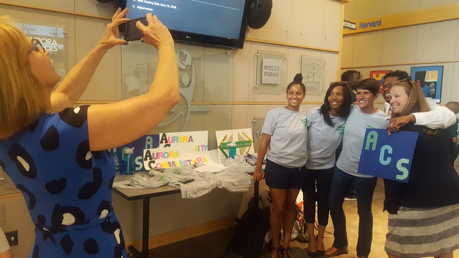 Two co-founders of Aurora Community School pose for a picture with supporters of the proposed school outside the board room. (Photo by Yesenia Robles, Chalkbeat)