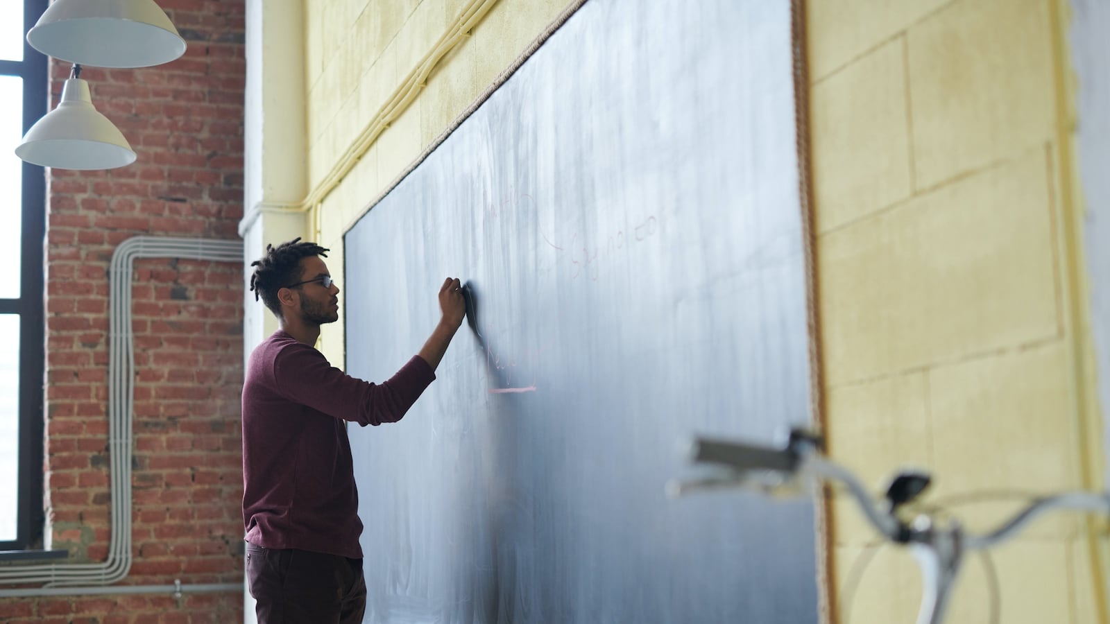 A teacher writes on a blackboard