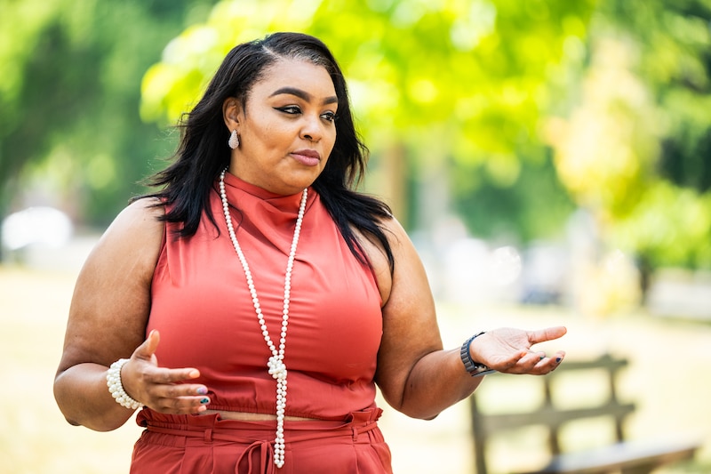 A portrait of a woman in a red top.