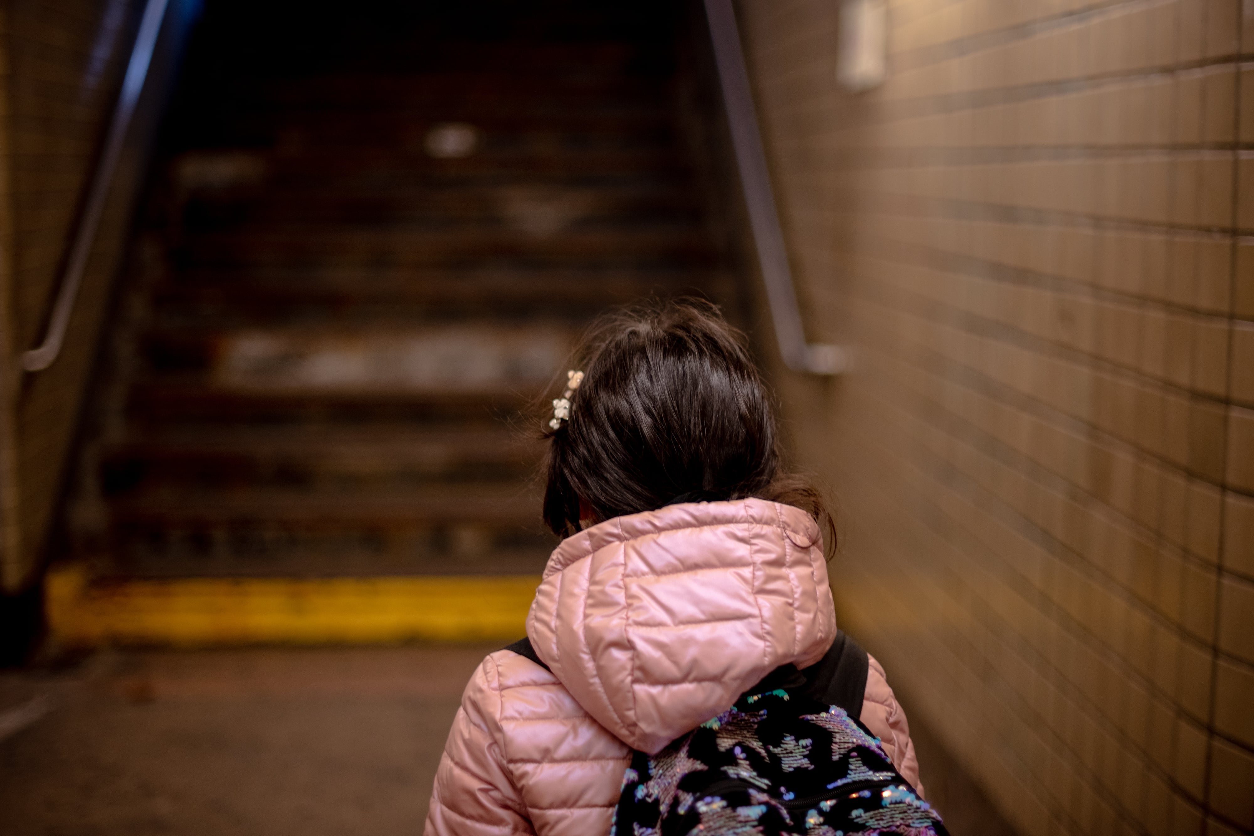 A view of the back of a young child's head in front of a set of stairs from a train.
