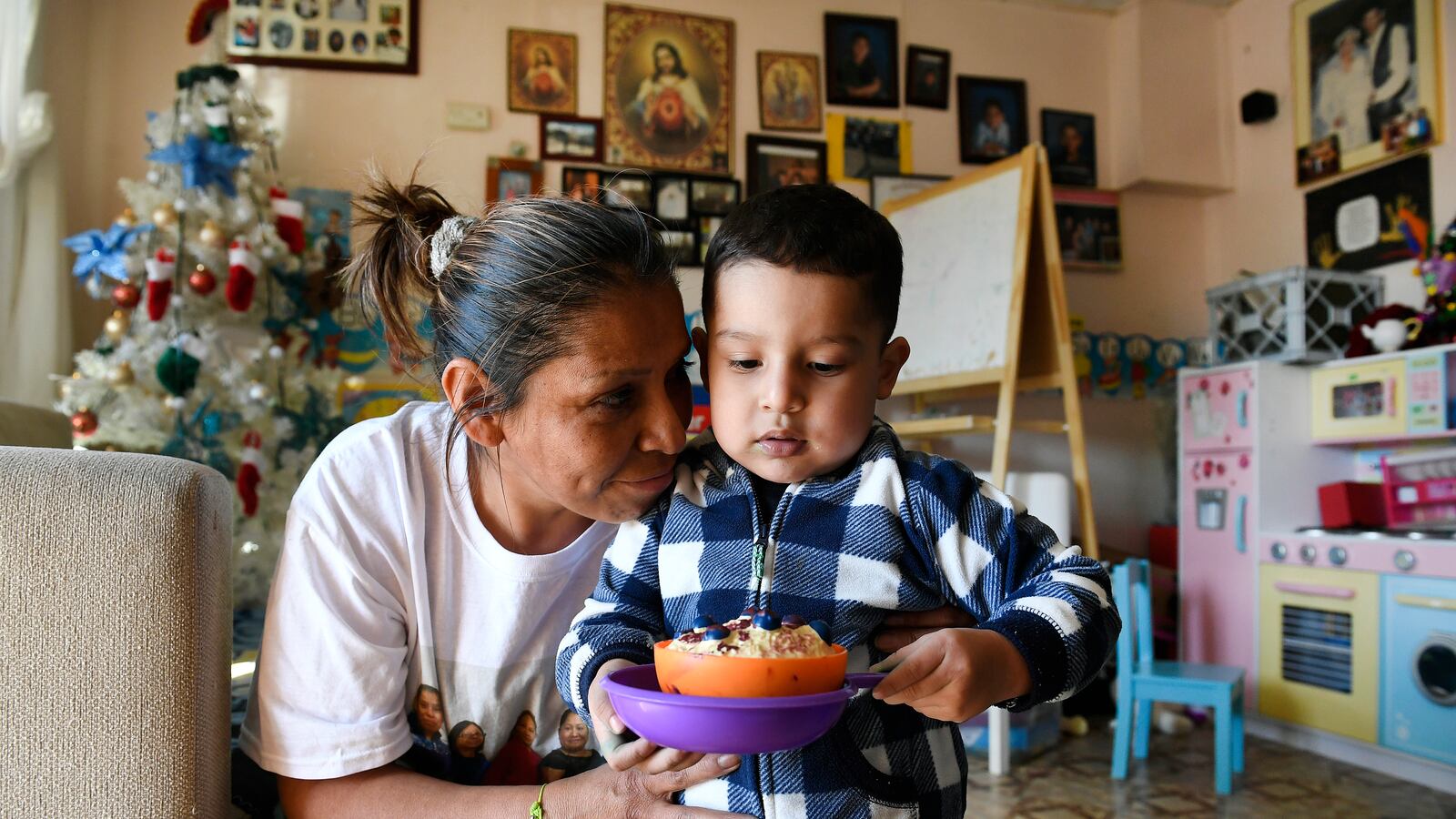Olga Montellano, an informal child care provider, says goodbye to Mateo Casillas, 2, after caring for him for the day.