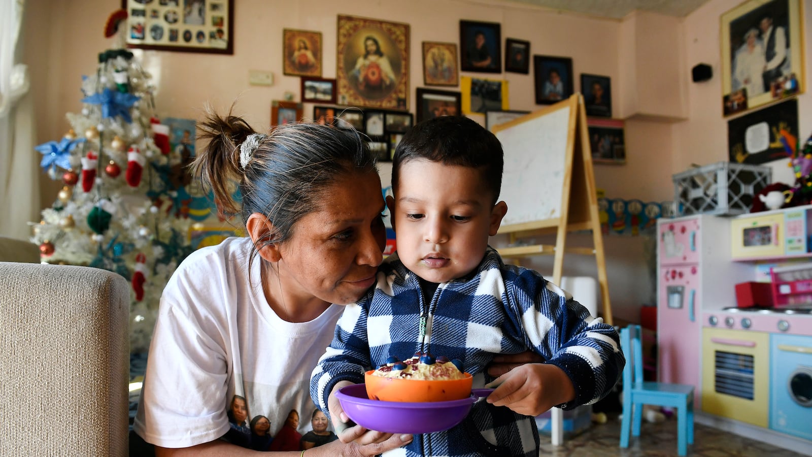 Olga Montellano, an informal child care provider, says goodbye to Mateo Casillas, 2, after caring for him for the day.