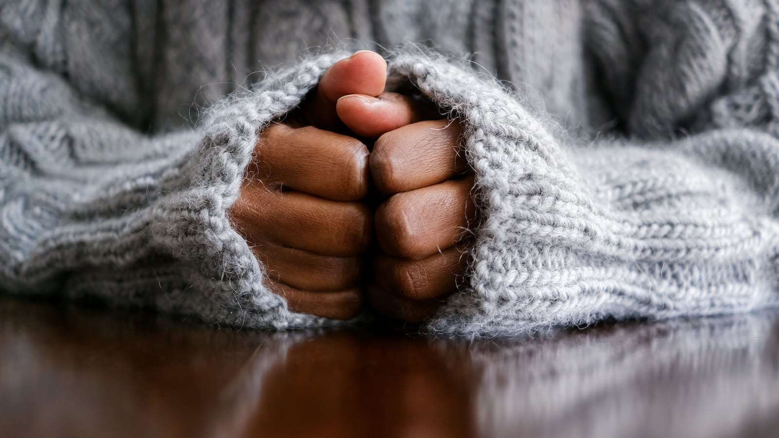 Close-up of unrecognizable black woman with hands on table