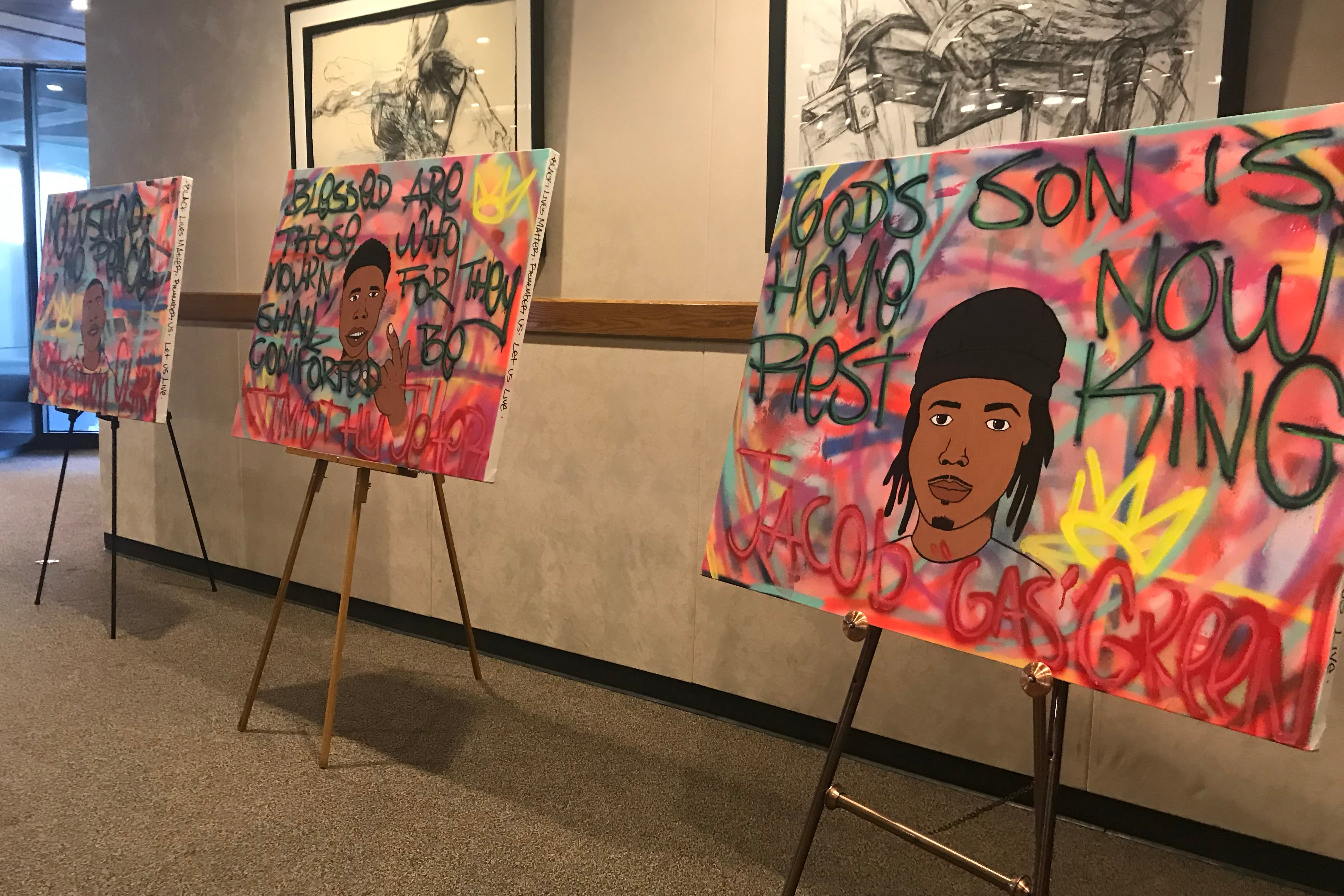 A photograph of three art pieces lined up in a room.