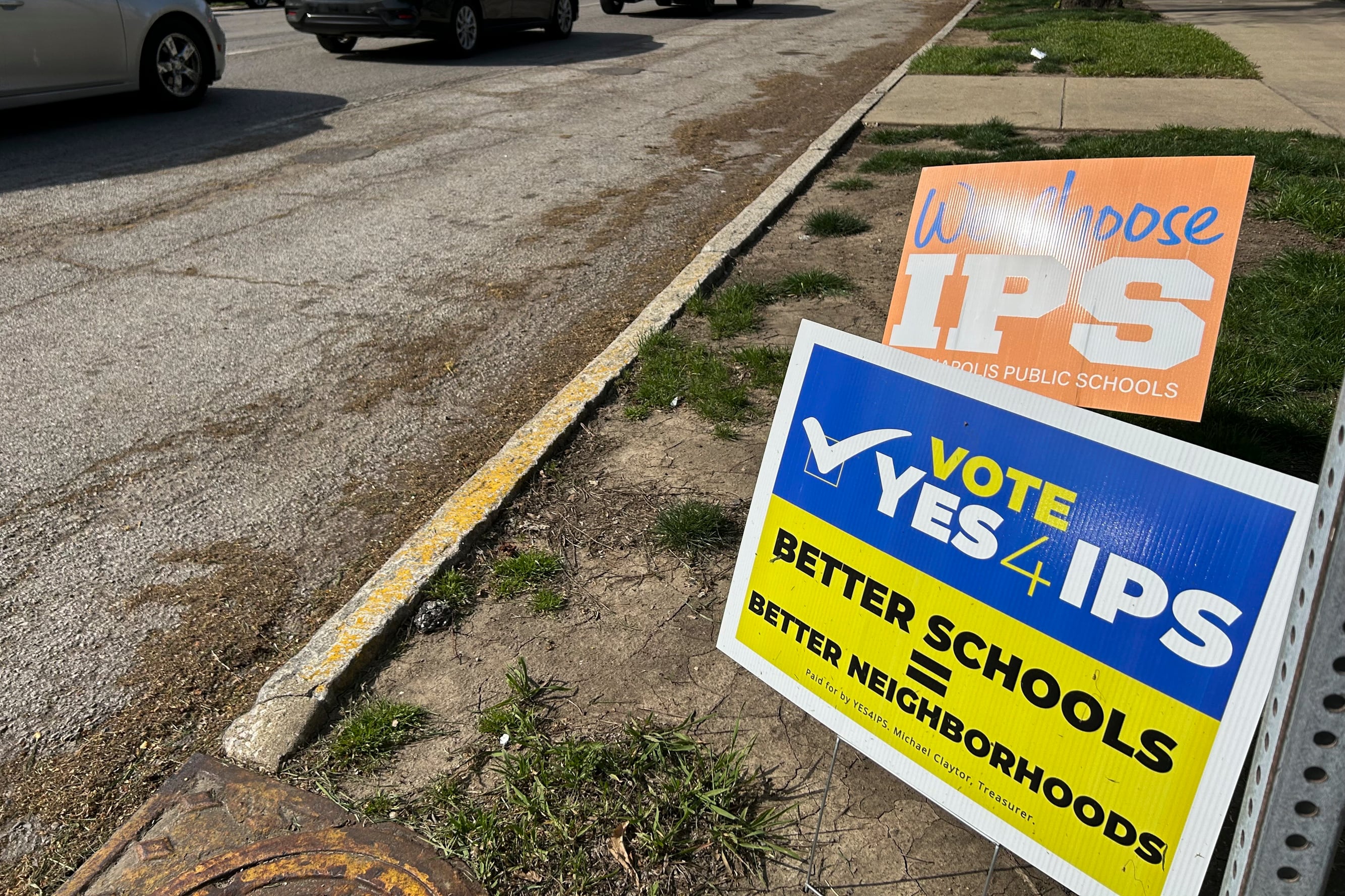 A blue-and-yellow sign that reads "Vote Yes 4 IPS."