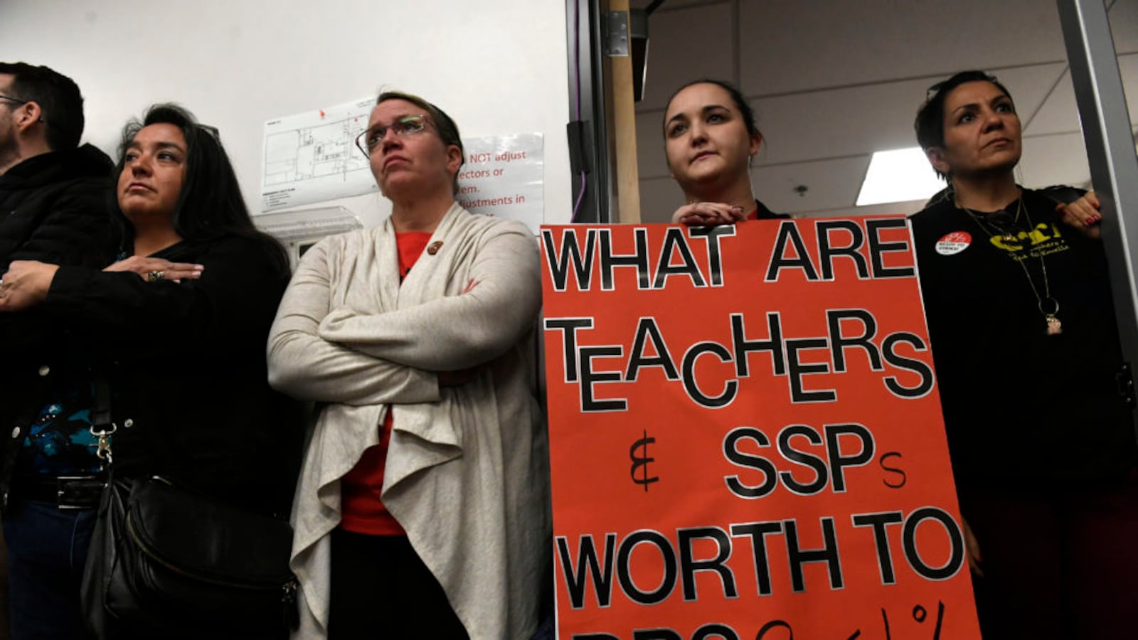 Jennifer Holtzmann, second from right, holds a protest sign during continued negotiations between DPS teachers and administrators.