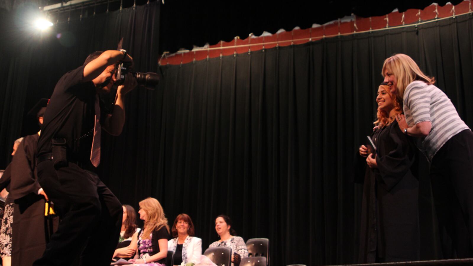 Sunset Park High School Principal Corinne Vinal poses with a graduate after she receives her diploma.