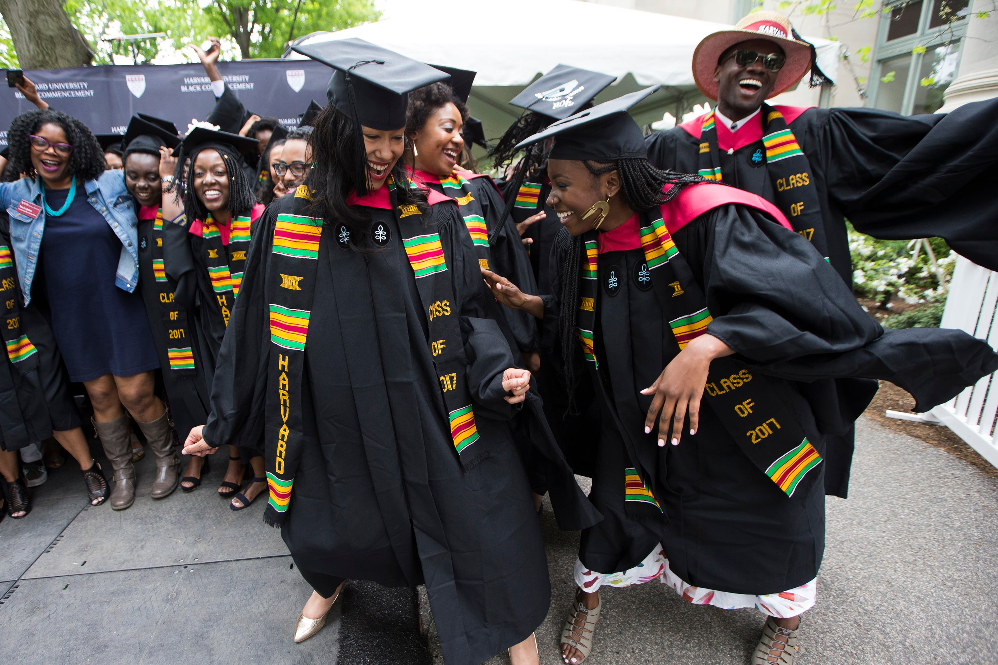 A group of college graduates celebrate outside.