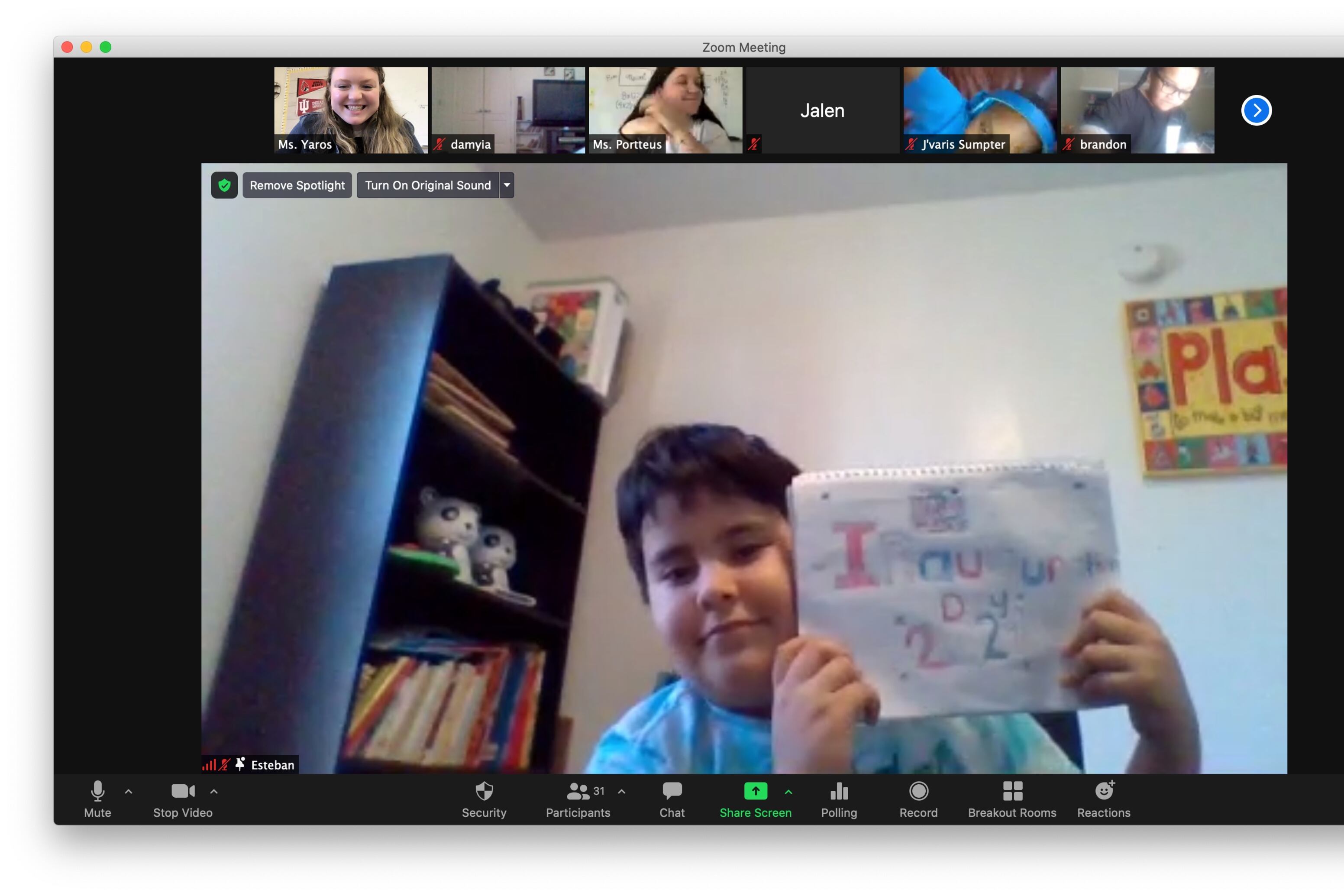 A student holds up a paper sign that says “Inauguration Day 2020” in a Zoom class