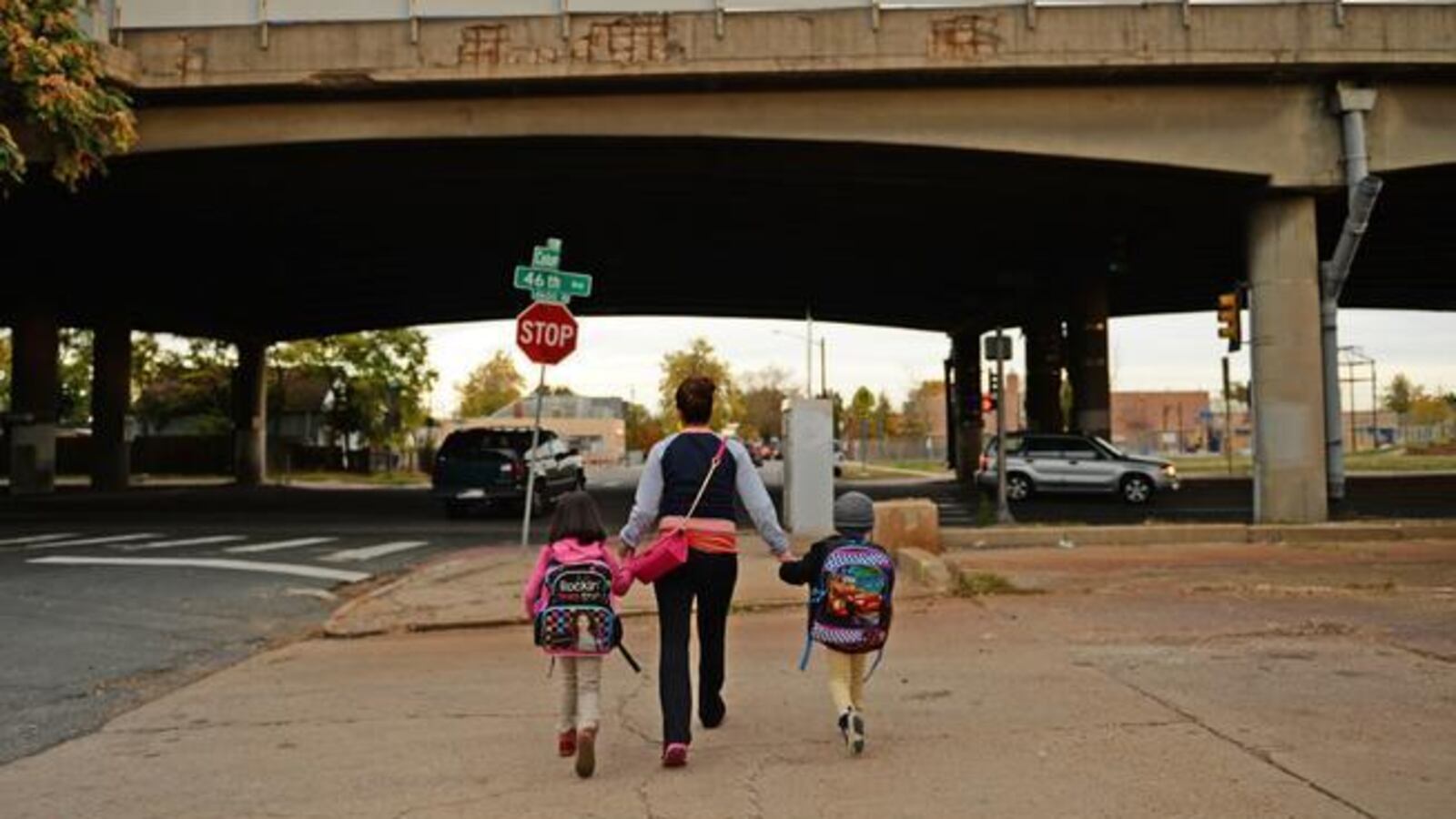 A Denver mother walks her children to Swansea Elementary just north of I-70 in this 2014 file photo.