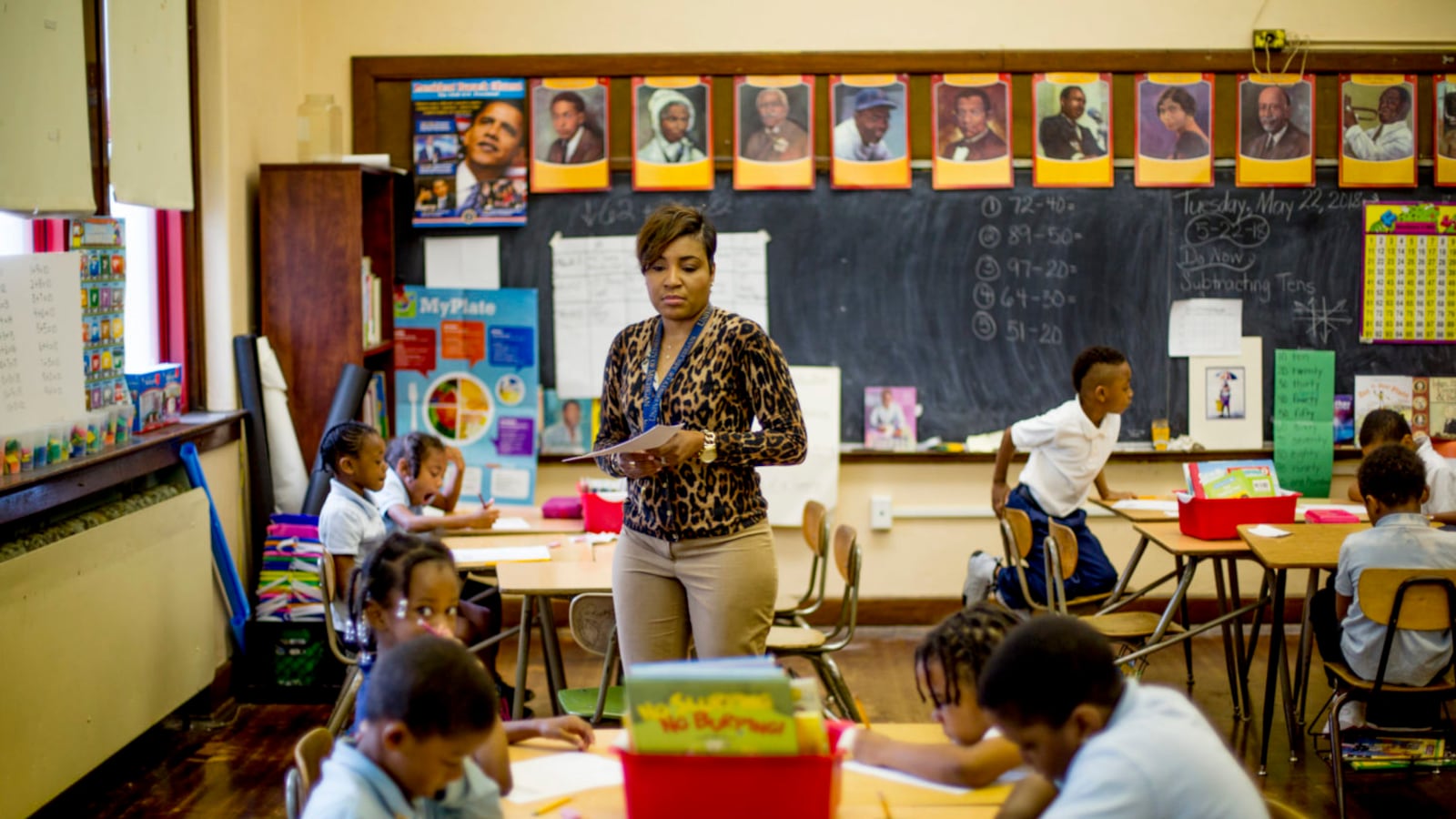 Rynell Sturkey teaches first-grade at Detroit’s Paul Robeson Malcolm X Academy. Several students work at desks around her.
