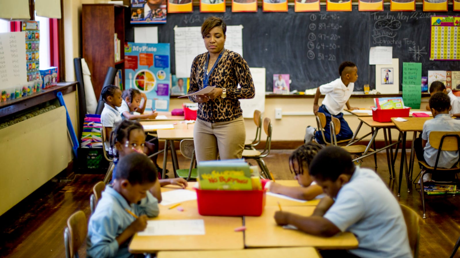 Rynell Sturkey teaches first-grade at Detroit’s Paul Robeson Malcolm X Academy. Several students work at desks around her.