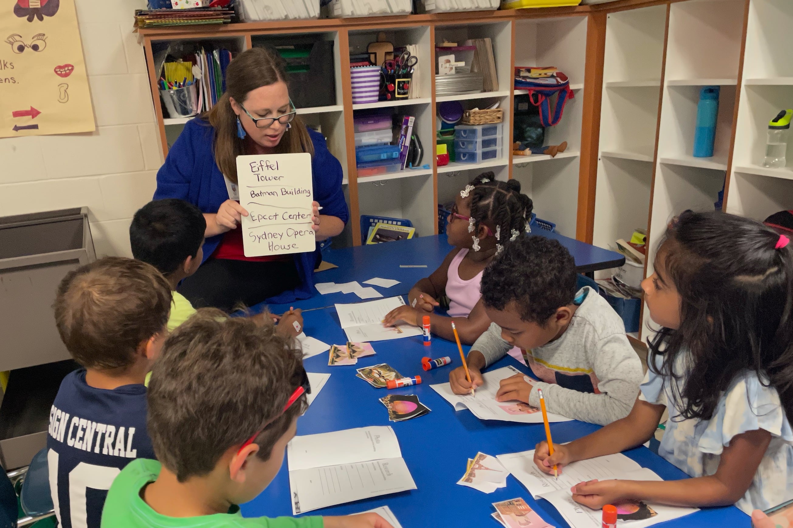 A teacher leads young students in a reading exercise.