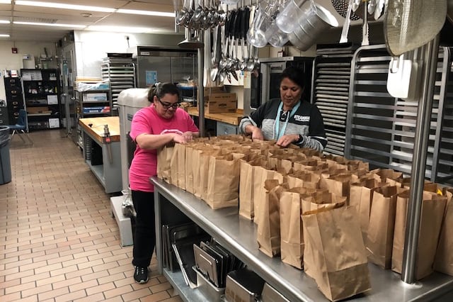 Sheridan staff prepare grab-and-go meals for students during school closures.