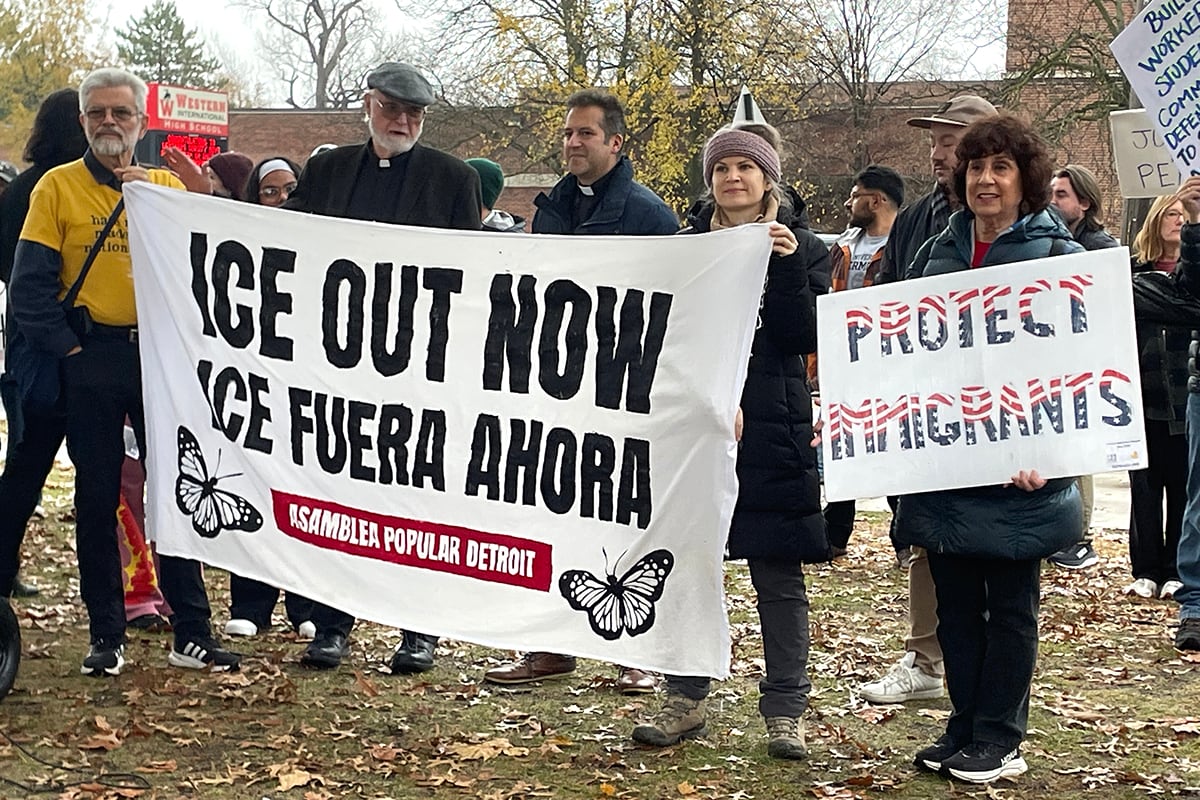 People hold signs at a rally.