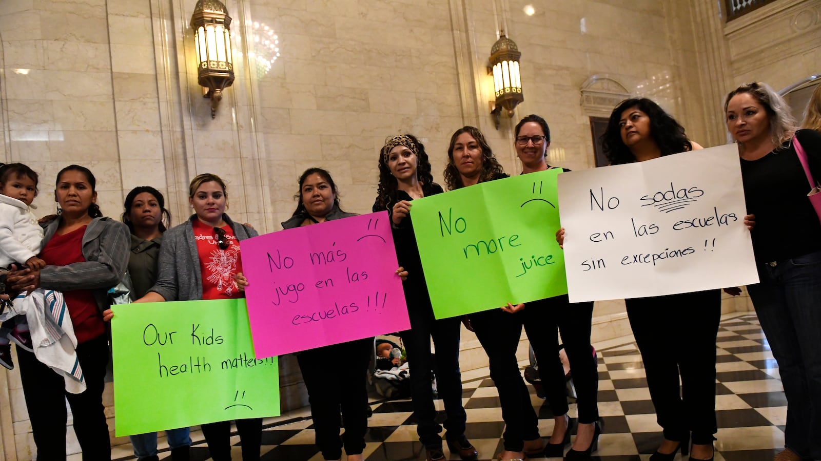 Members of the group Westwood Unidos, hold up signs of protest in the lobby of the State Board of Education. (Photo by Helen H. Richardson/The Denver Post)